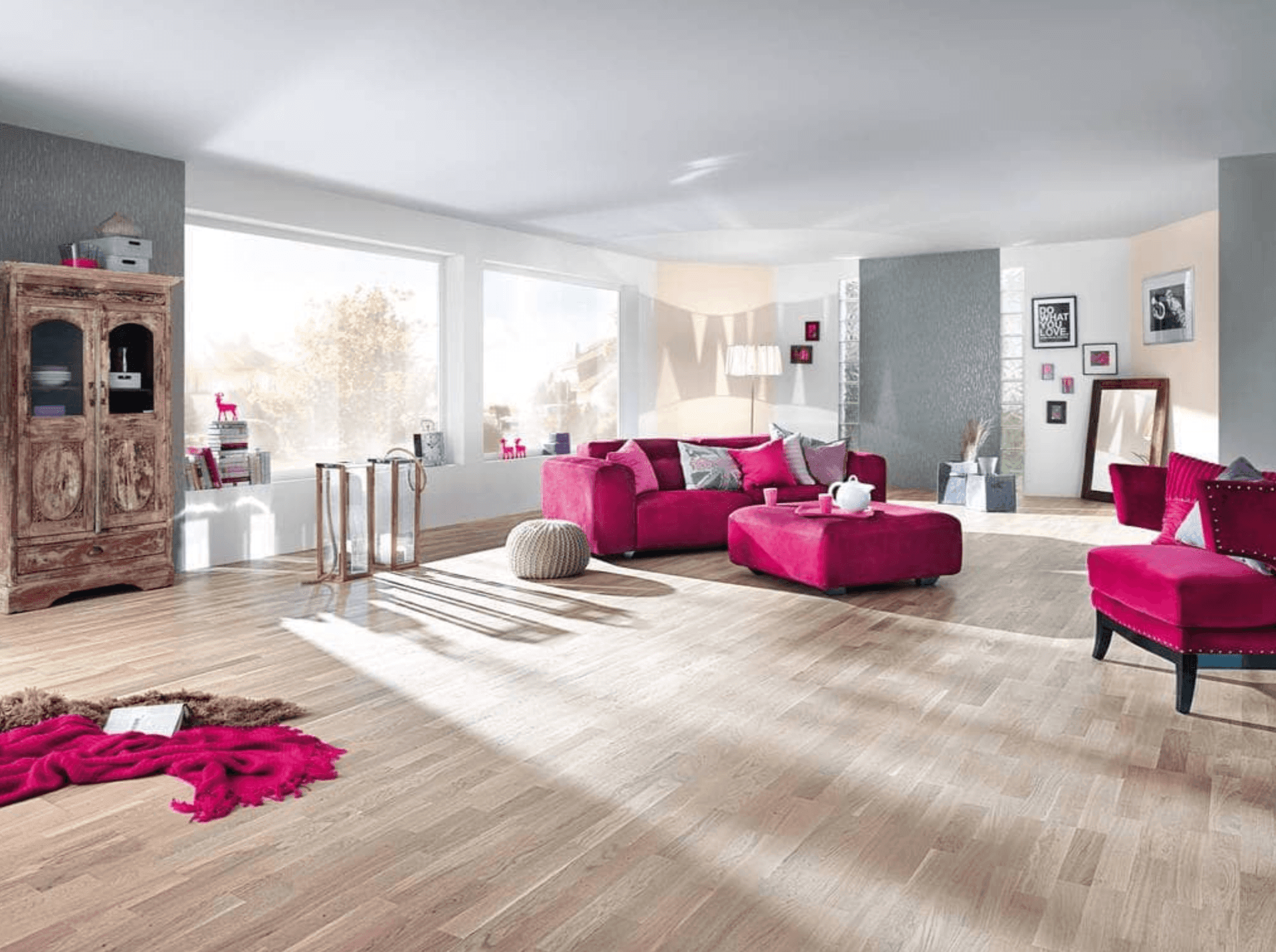 Bright living room with pink sofas, wooden floor, and large windows.