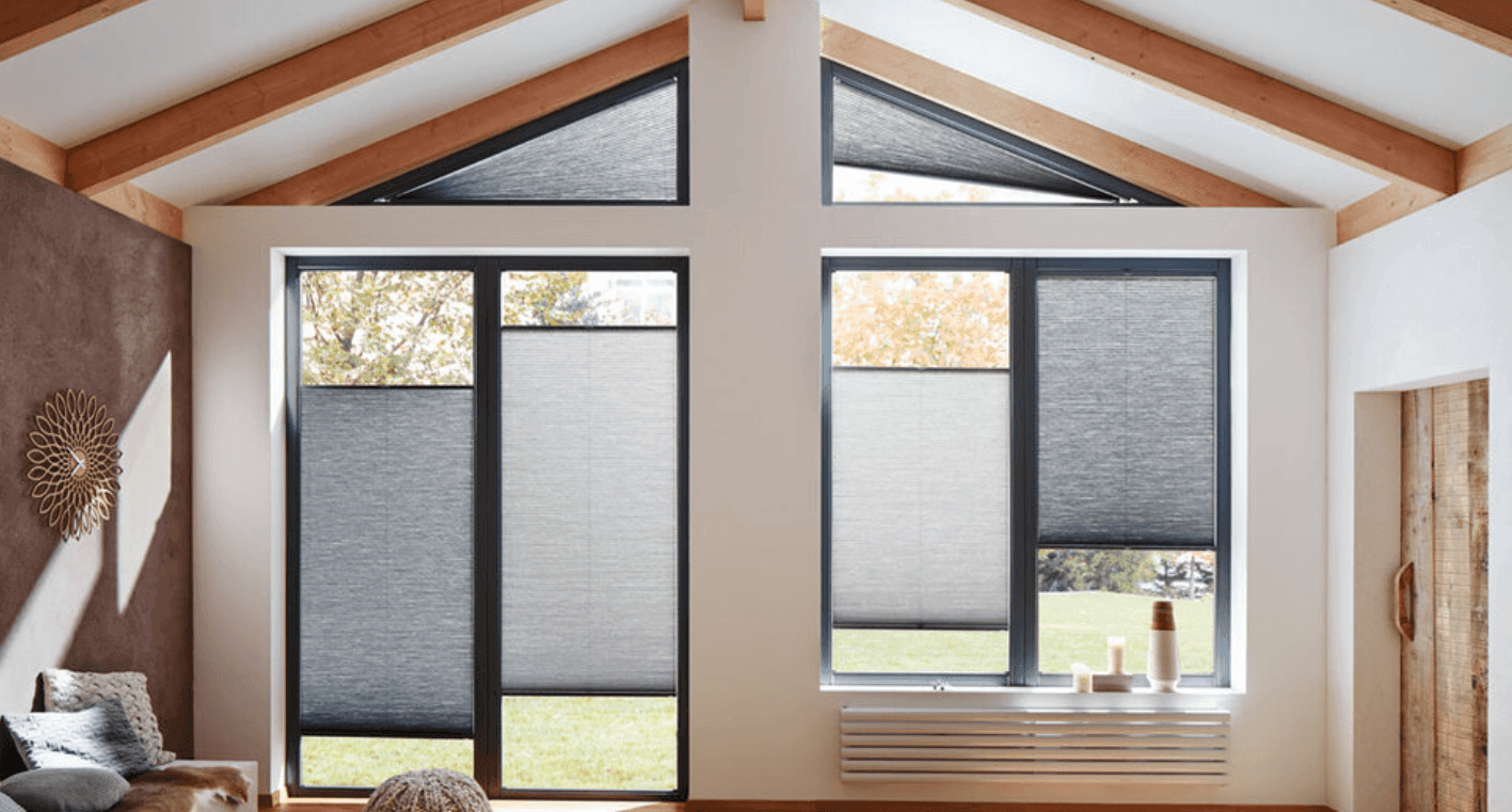 Modern living room with large windows, gray blinds, and wooden beam ceiling.